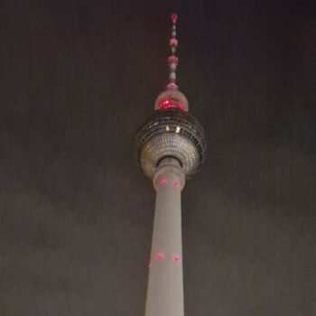Night view of the Berlin TV Tower, with the city skyline in the background.