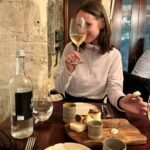 women holding a glass of Maltese wine and eating starters at the michelin restaurant Guze Valletta Malta
